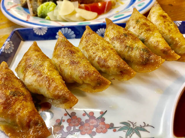 A row of golden colored crispy gyoza on a plate