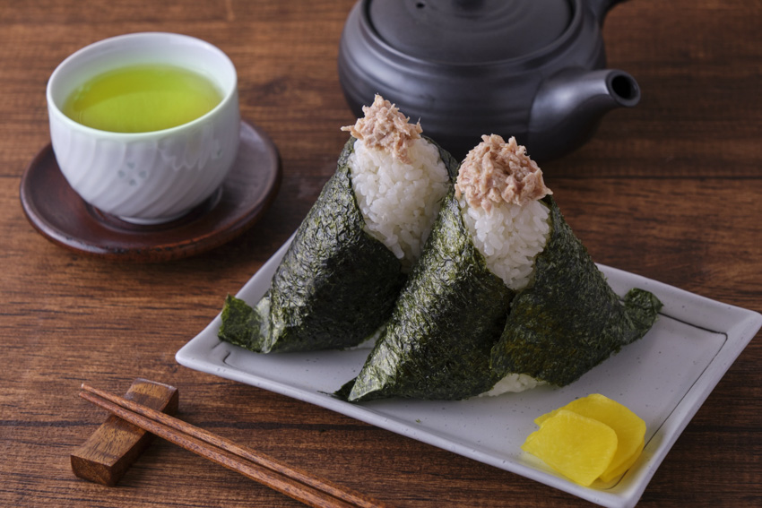 Two tuna mayonnaise onigiri on a plate. 