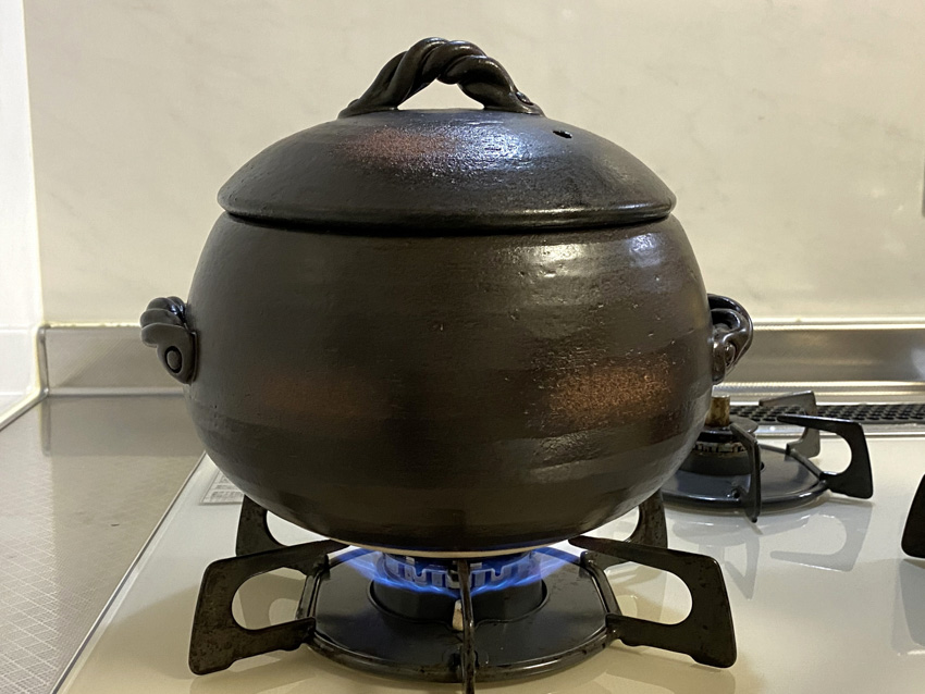 Pot of rice with the lid closed on a gas stove.