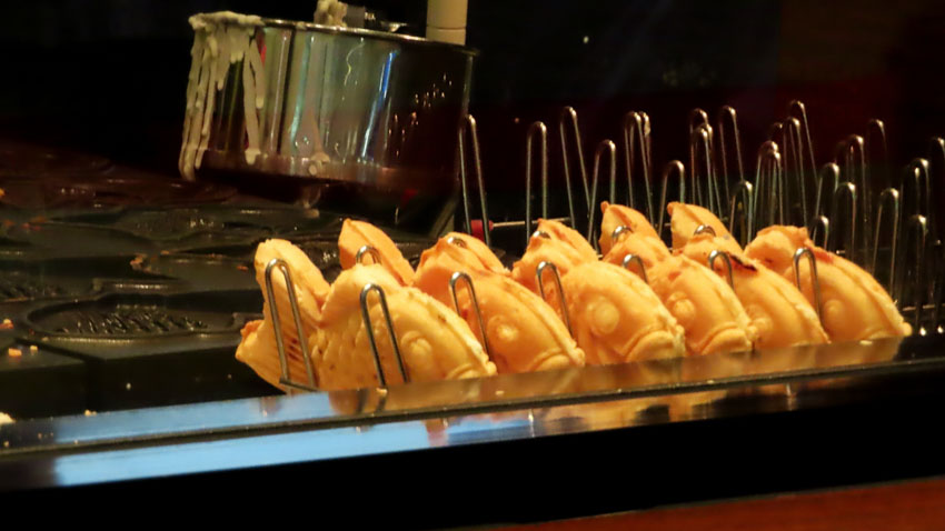 Freshly made taiyaki cooling off next to the grill iron