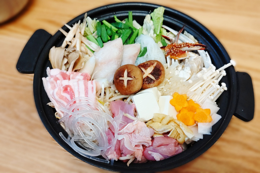 Yosenabe pot filled with vegetables, mushrooms, meat and seafoodprior to cooking