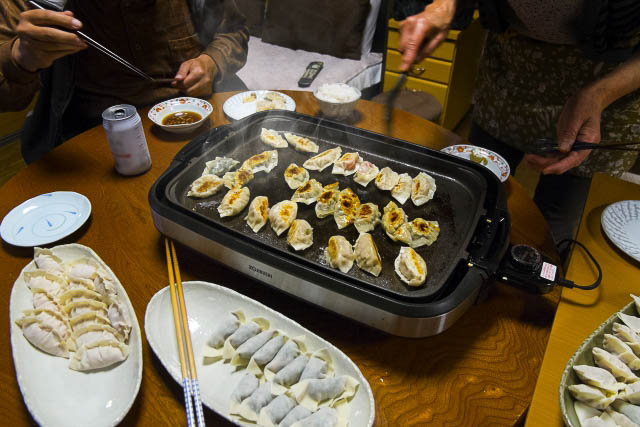 Gyoza being cooked on a hot plate on a dining table