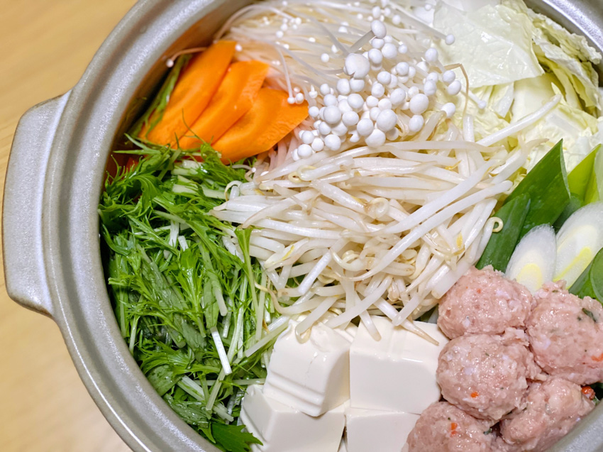 Mizutaki nabe pot filled with vegetables, chicken balls, tofu before cooking