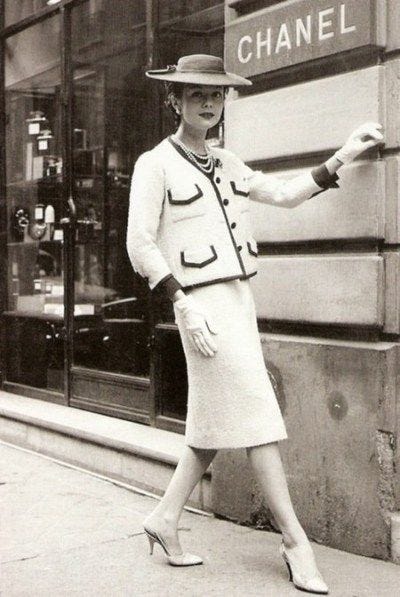 Coco Chanel in her younger years in front of one of her stores