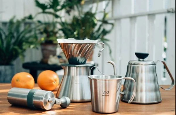 Coffee brewing tools such as a kettle, a dripper, a mug and a coffee manual grinder.