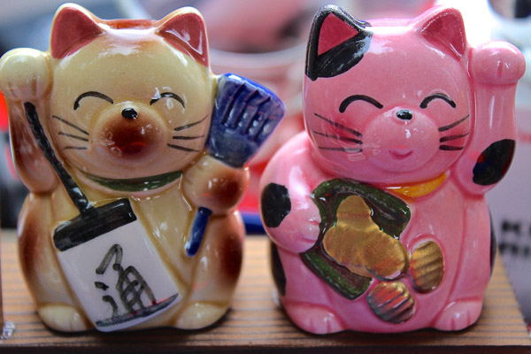 Close up of a right paw up beige and a left paw up pink maneki neko