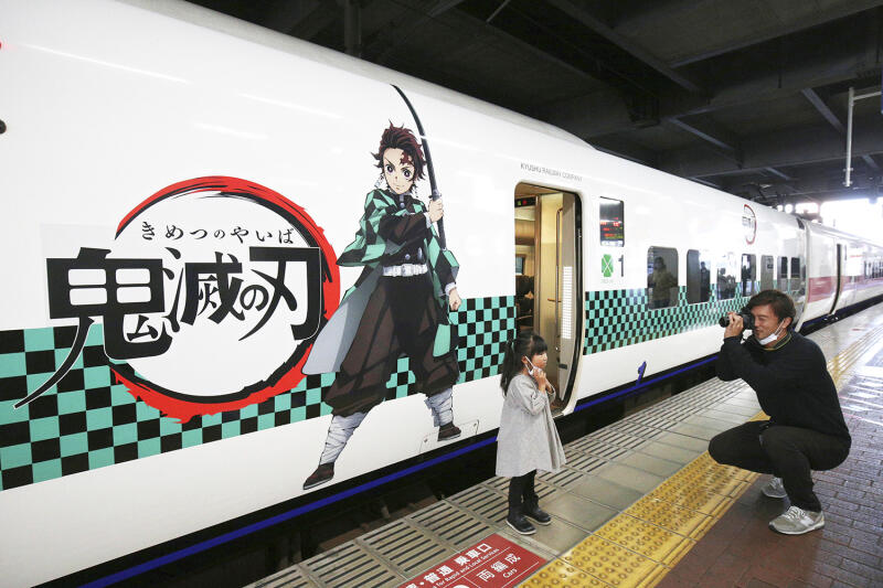 Demon Slayer themed bullet train with a father and his daughter standing in front of it